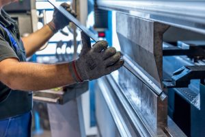 Close up image of a person fixing equipment in a manufacturing facility